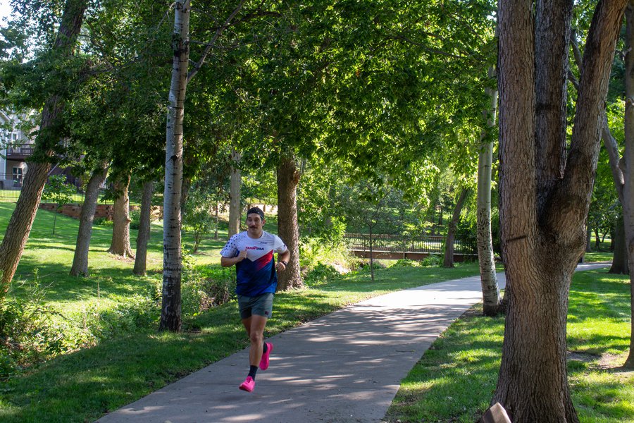 Andrew Tupper runs through a bright green park in Bellevue.